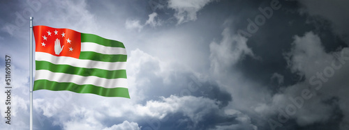 Abkhazian flag isolated on a cloudy sky photo