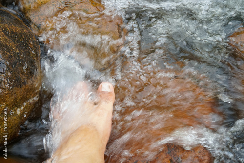 Human foot under stream for relaxing