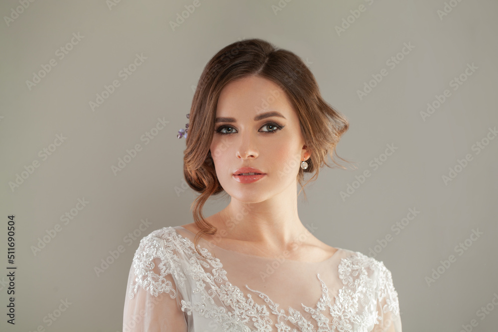Beautiful young elegant stylish brunette woman looking at camera on gray studio background Beautiful young elegant stylish brunette woman looking at camera on gray studio background