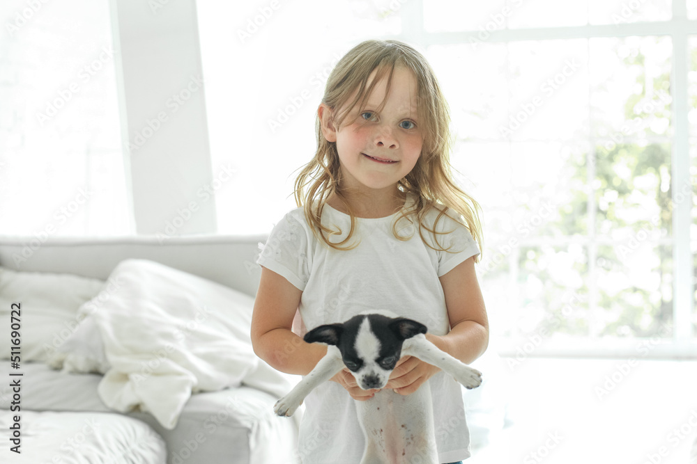 Little child girl embracing her puppy pet at home Little child girl embracing her puppy pet at home