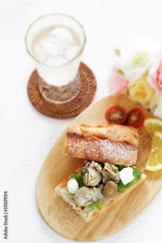 Canned smoked oyster in french bread sandwich served with soda 