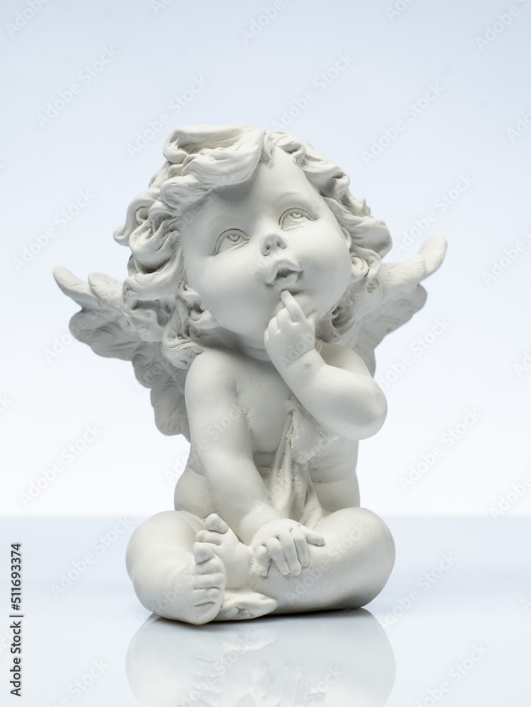 plaster white statuette in the form of an angel on a white background