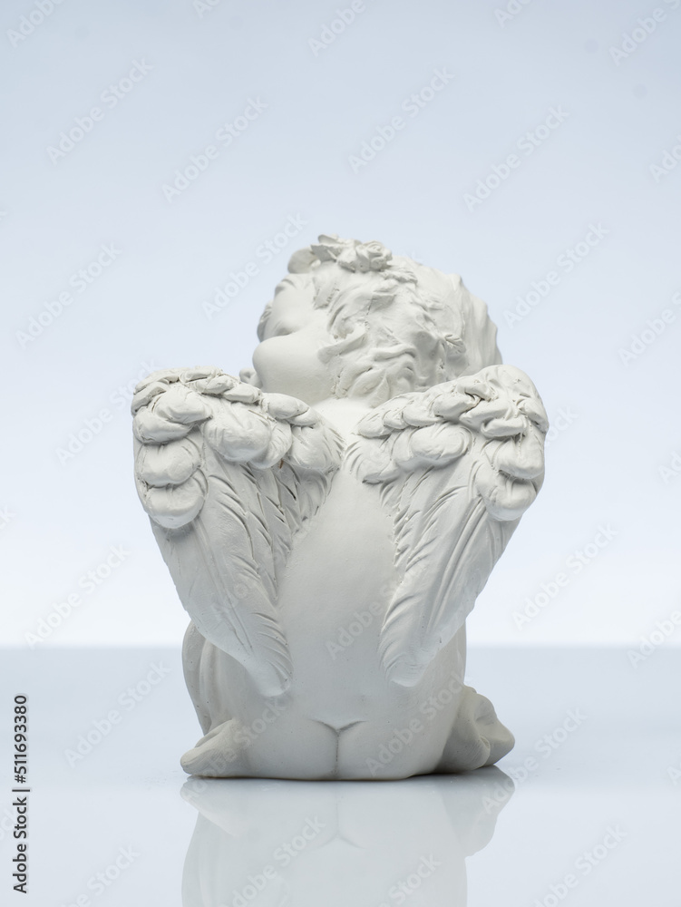 Obraz premium plaster white statuette in the form of an angel on a white background