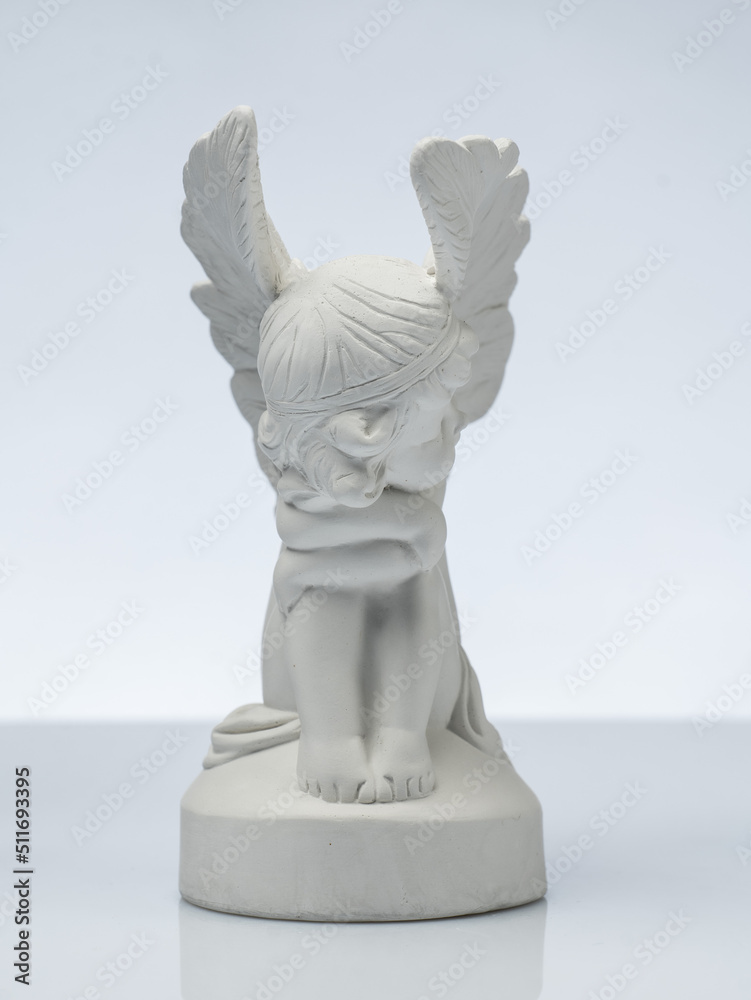 plaster white statuette in the form of an angel on a white background plaster white statuette in the form of an angel on a white background