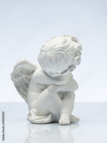 plaster white statuette in the form of an angel on a white background © Vasily Popov