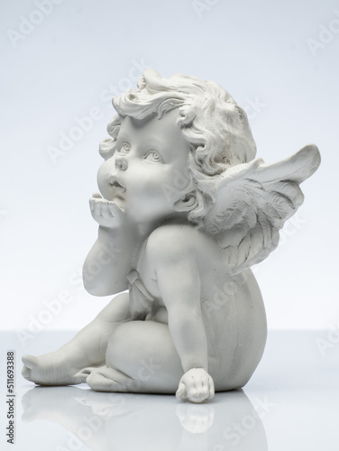 Fotobehang plaster white statuette in the form of an angel on a white background