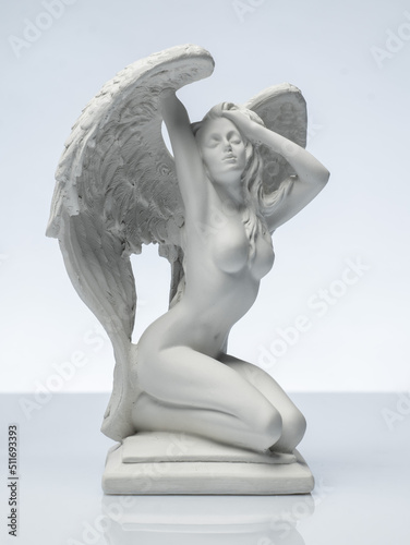 plaster white statuette in the form of an angel on a white background