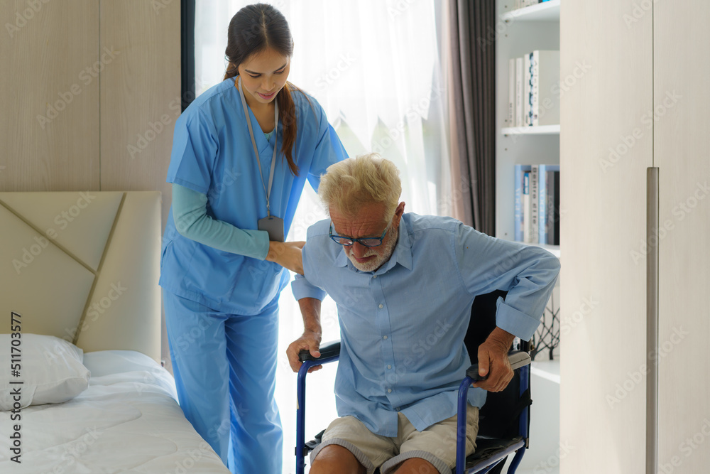 Asian smiling nurse helping senior man get out of bed nursing care