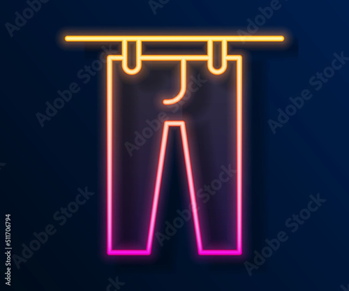Glowing neon line Drying clothes icon isolated on black background. Clean pants. Wash clothes on a rope with clothespins. Clothing care and tidiness. Vector