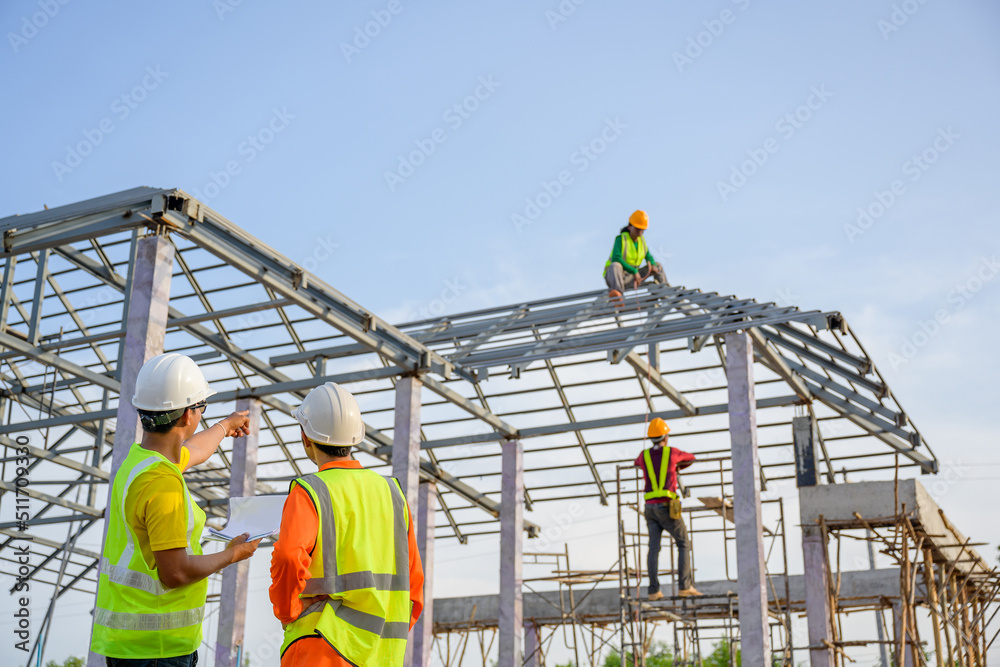 A team of construction engineers stand at a house construction site. Talk to Foreman and workers to check the quality and come up with a plan. steel roof construction