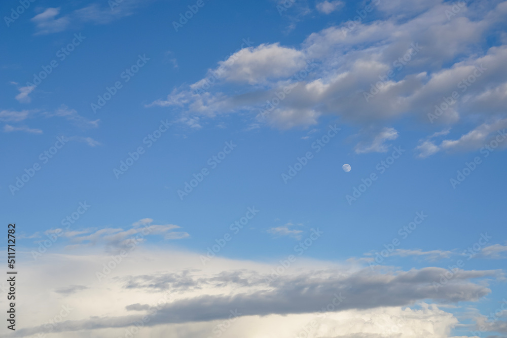 Fototapeta premium Background with white clouds and moon in the blue sky in the early evening