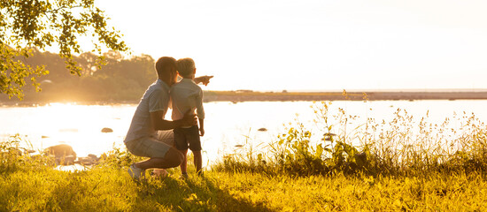 Father and his little son. Happy loving family walking outdoor in the light of sunset.