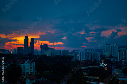 sunset with dark rainy clouds over modern city