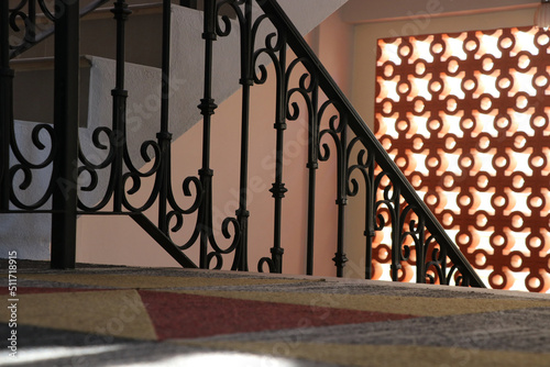 The vintage metal style  stair railing and  orange carpet decorated by orange bricks