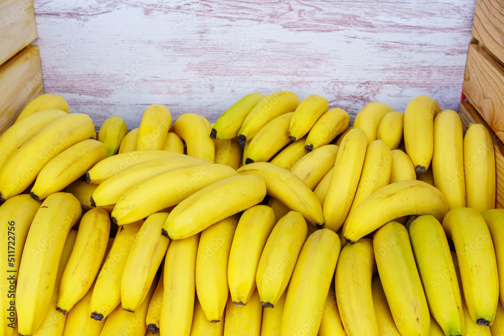 A large pile of appetizing looking yellow bananas in a container box, copy space.