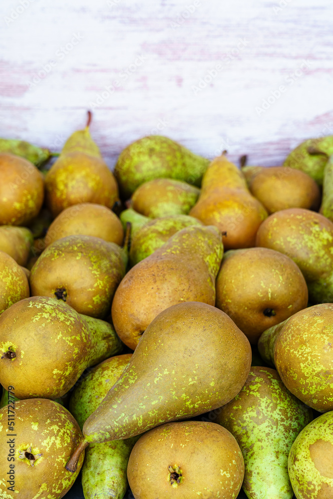 Many green conference type pears placed in a raw container, copy space.