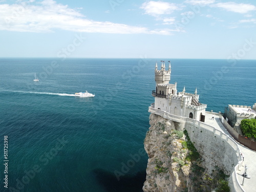 Castle Swallow's Nest on the rock over the Black Sea close-up, Crimea. It is a tourist attraction of Crimea. Amazing aerial view of the Crimea coast with the castle above abyss on sunny day.