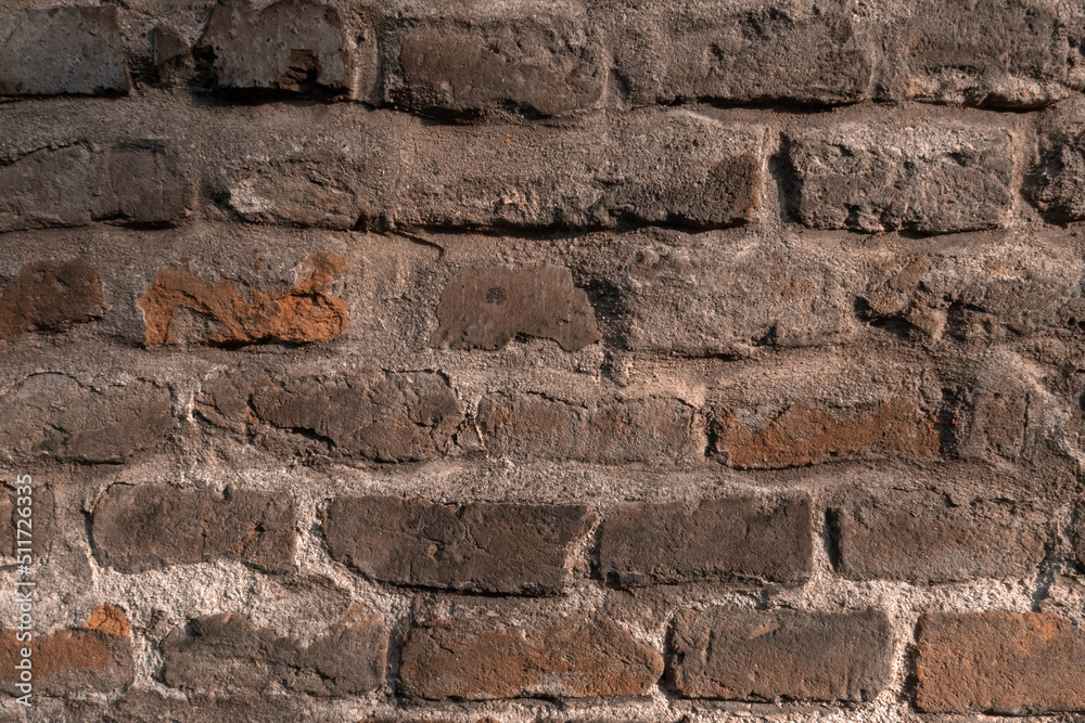 Demaged Rough Brick Wall Surface. Old Brown and Red Brick Wall in the Light of the Setting Sun. Cool Background. Medieval Wall. Demaged Rough Brick Wall Surface. Old Brown and Red Brick Wall in the Light of the Setting Sun. Cool Background. Medieval Wall.