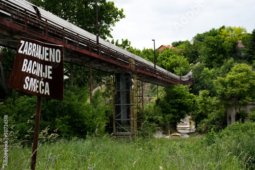 Old conveyor belt for the mine, near Beočin, Serbia. With sign, dont throw garbage. photo