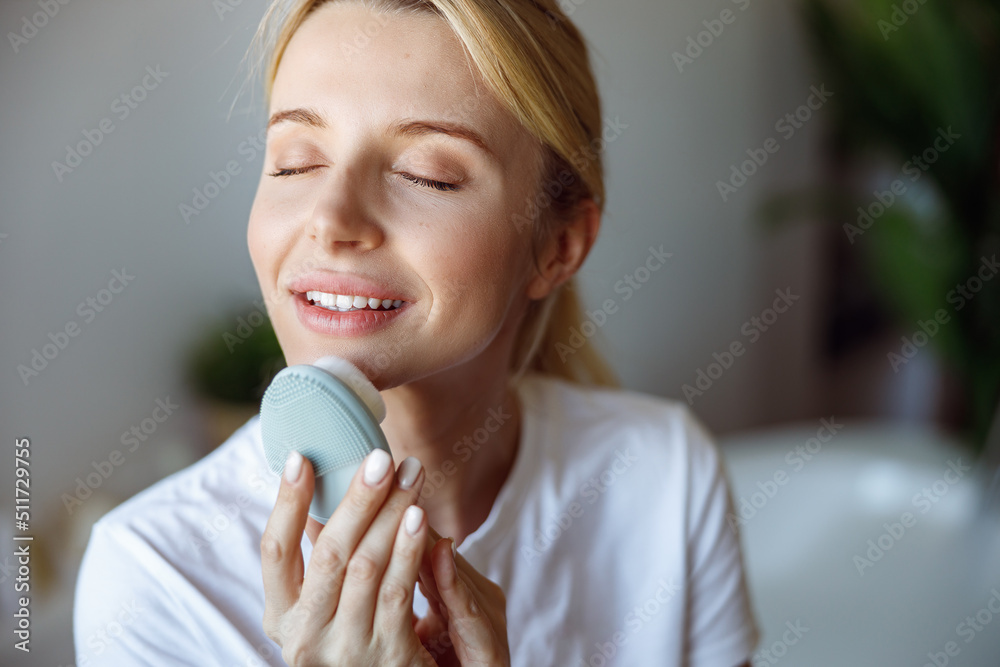 Close up of young beautiful blonde woman massaging face with electro brush. Relax. Close up of young beautiful blonde woman massaging face with electro brush. Relax.