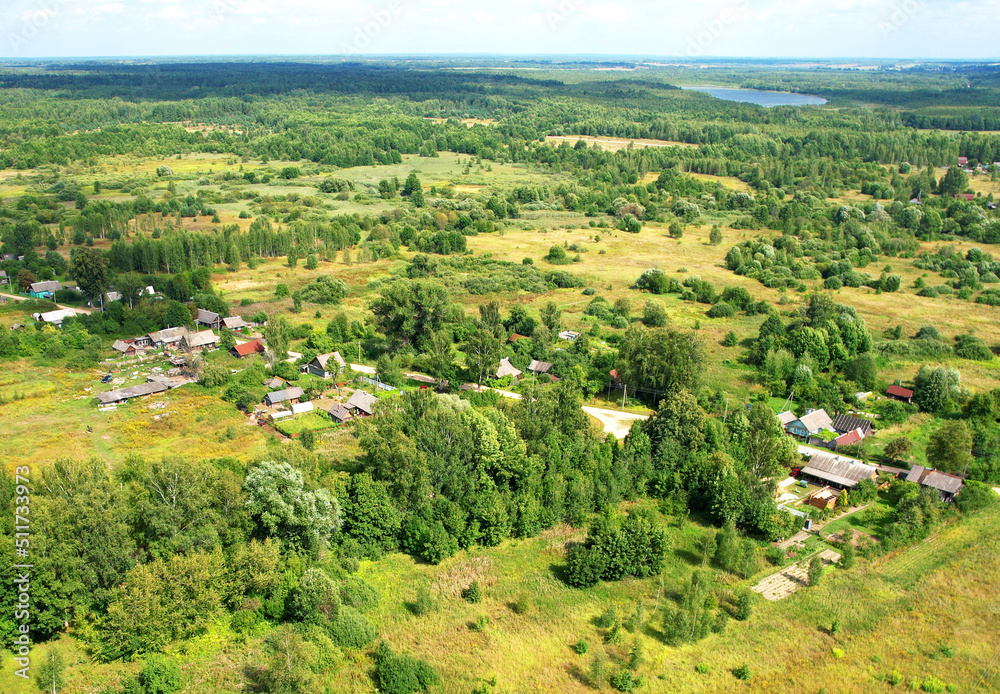 Obraz premium Rural building and farmhouse in countryside. Country houses in countryside, aerial view. Building a Houses in сountry. Village with wooden house. Suburban house in rural. Roofs of village home.