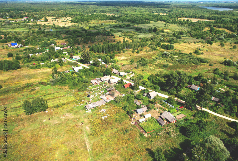 Fototapeta premium Rural building and farmhouse in countryside. Country houses in countryside, aerial view. Building a Houses in сountry. Village with wooden house. Suburban house in rural. Roofs of village home.