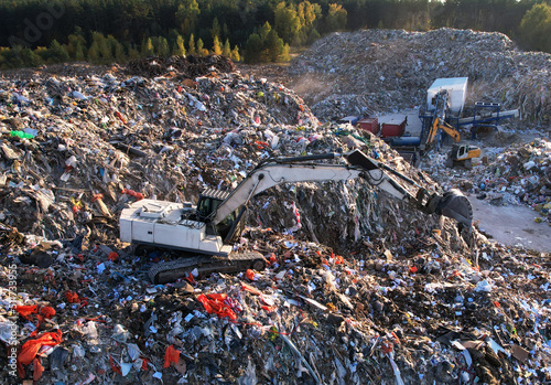 Landfill with Construction and Demolition waste (CDW). Trash disposal for recycling and re-use. Excavator working on industrial landfill. Recycling of building waste materials. Secondary raw.