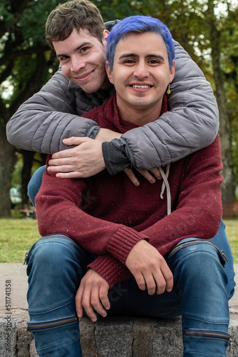 Gay male couple hugging and looking at camera outdoors © Valeria Venezia