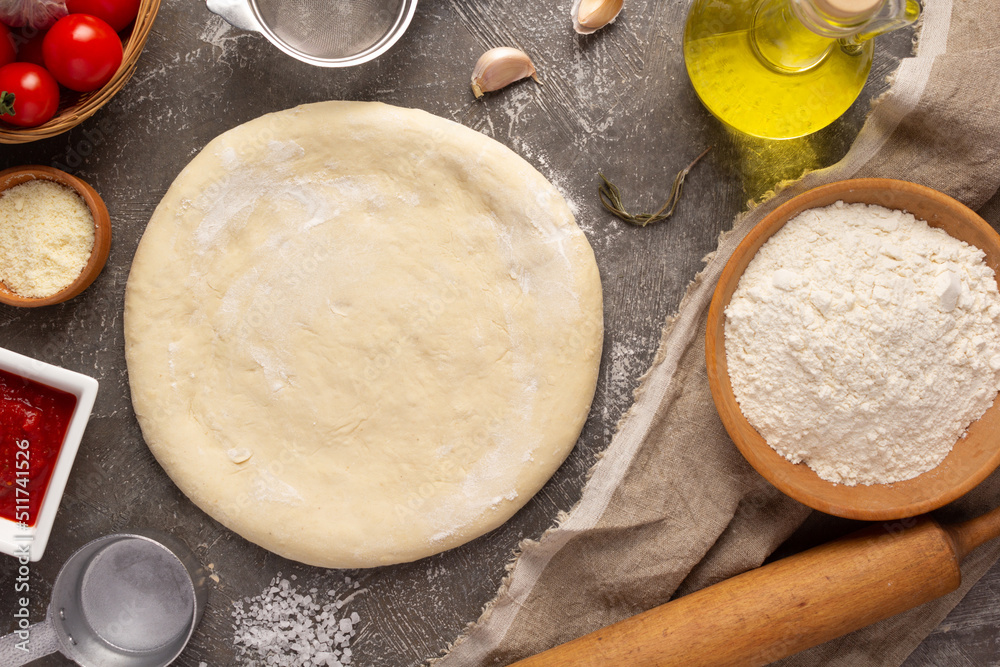 Pizza or dough for bread with ingredients at table. Pizza recipe homemade at tabletop background Pizza or dough for bread with ingredients at table. Pizza recipe homemade at tabletop background