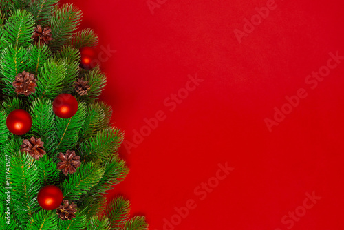 postcard from the branches of a Christmas tree with pine cones and red balls on a saturated background  copy space.