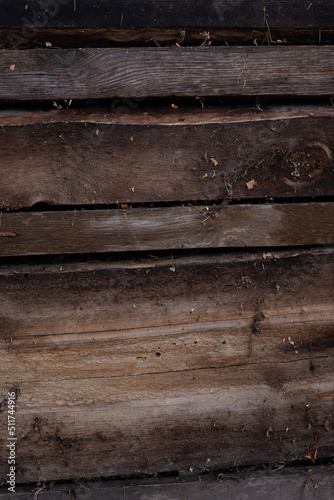 Wall is made of dirty old boards. Background is made of dark brown wood covered with dust and cobwebs, with copy space. 