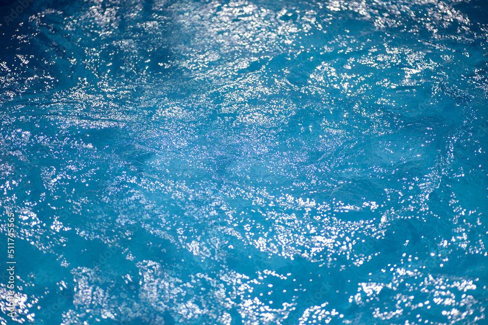 Fototapeta premium sparkling water surface in the pool in the sun, summer minimalistic calm background with copyspace. 