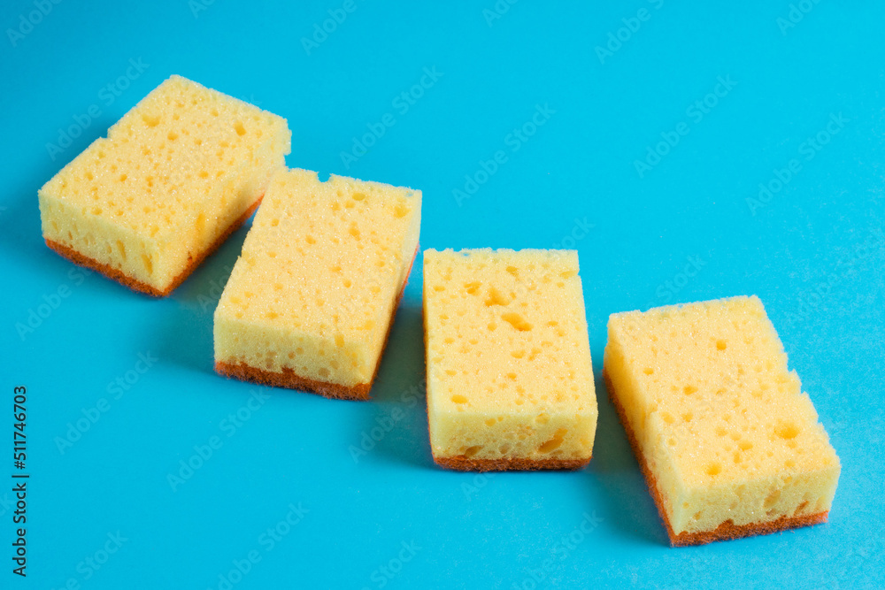 Sponges for washing dishes and cleaning in the apartment on a blue background. The concept of using environmentally friendly detergents for the home