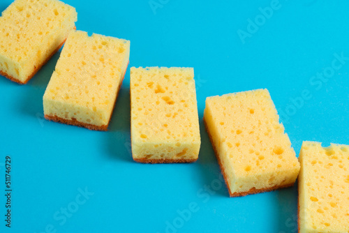 Sponges for washing dishes and cleaning in the apartment on a blue background. The concept of using environmentally friendly detergents for the home