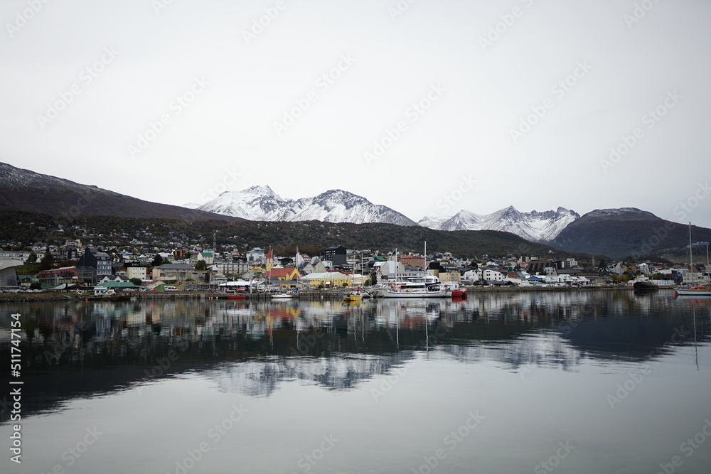 the photo captures the beautiful landscape of the city of Ushuaia, with houses of Argentine architecture and a beautiful view of the lake.