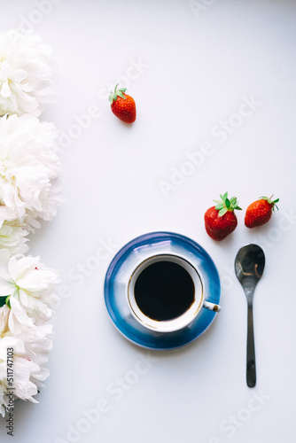 Cup of coffee, peonies and strawberries on white background 