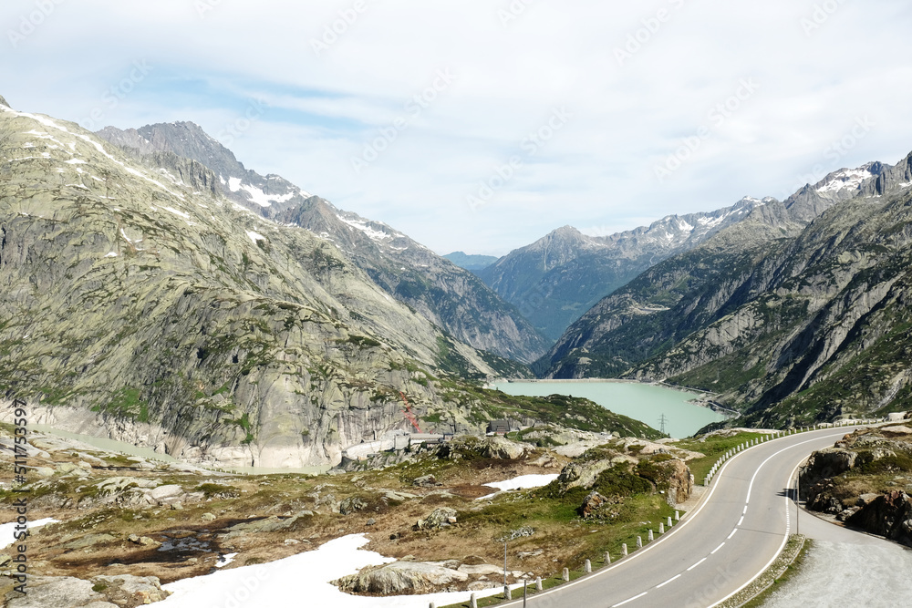 A picture of mountain, dam and road at Grimsel Pass. The Grimsel Pass links the Hasli Valley in the Bernese Oberland with Goms in Valais.