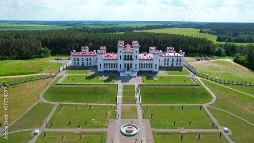Aerial view of Kossovo castle with beautiful red roof. Restored ancient castle-palace of Paslovsky Kosovo, Belarus. Construction aerial view height photo