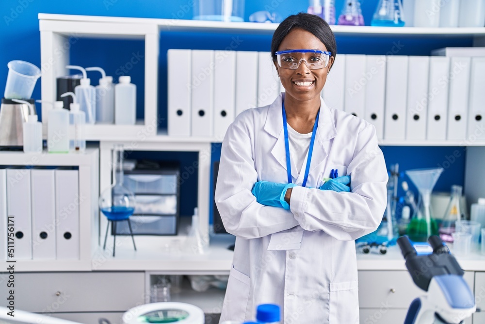 Young african american woman scientist smiling confident standing with arms crossed gesture at laboratory Young african american woman scientist smiling confident standing with arms crossed gesture at laboratory