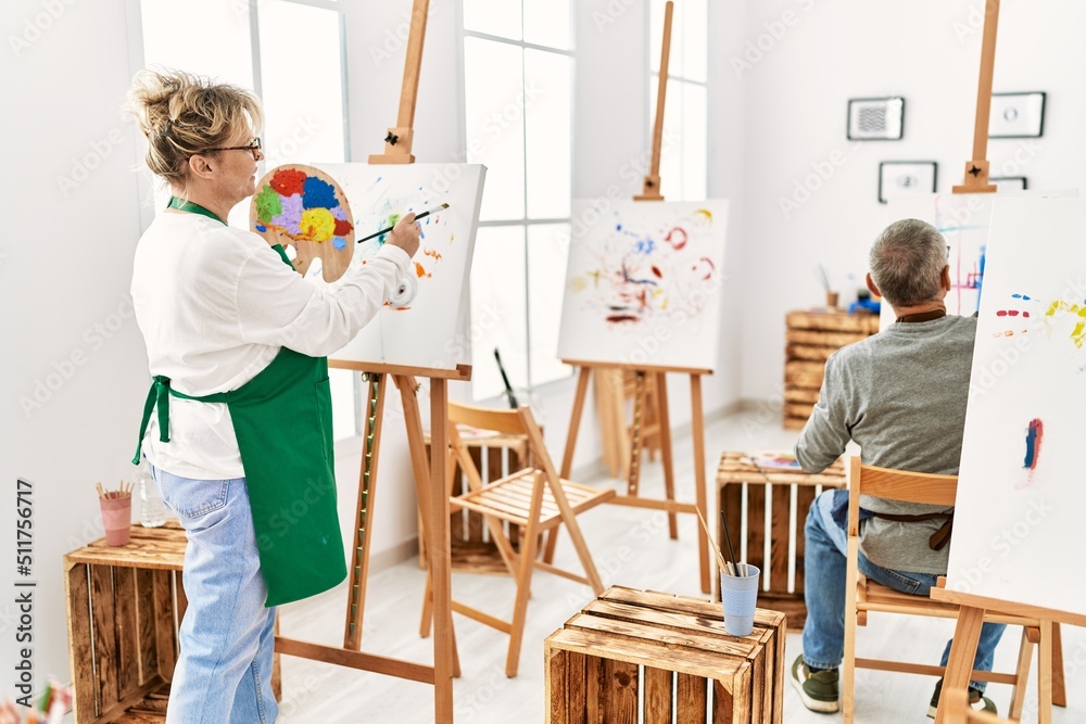 Two senior paint student smiling happy painting at art studio. Two senior paint student smiling happy painting at art studio.