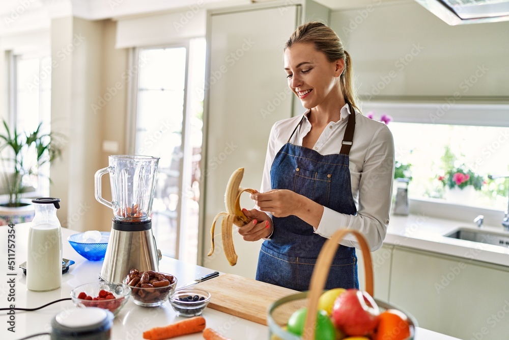 Young blonde woman smiling confident peeling banana at kitchen Young blonde woman smiling confident peeling banana at kitchen