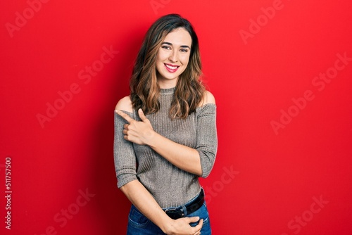 Young hispanic girl wearing casual clothes smiling cheerful pointing with hand and finger up to the side © Krakenimages.com