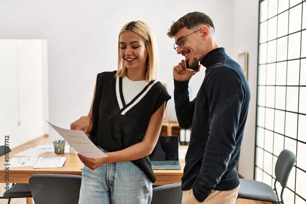 Two business workers smiling happy working and talking on the smartphone at the office. Two business workers smiling happy working and talking on the smartphone at the office.