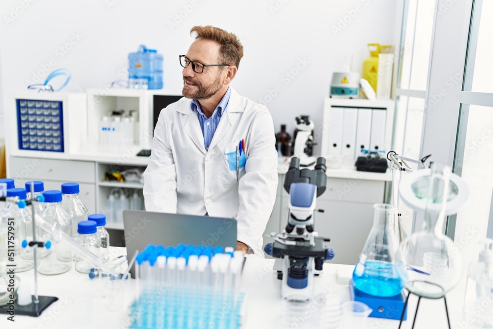 Middle age hispanic man wearing scientist uniform working at laboratory Middle age hispanic man wearing scientist uniform working at laboratory