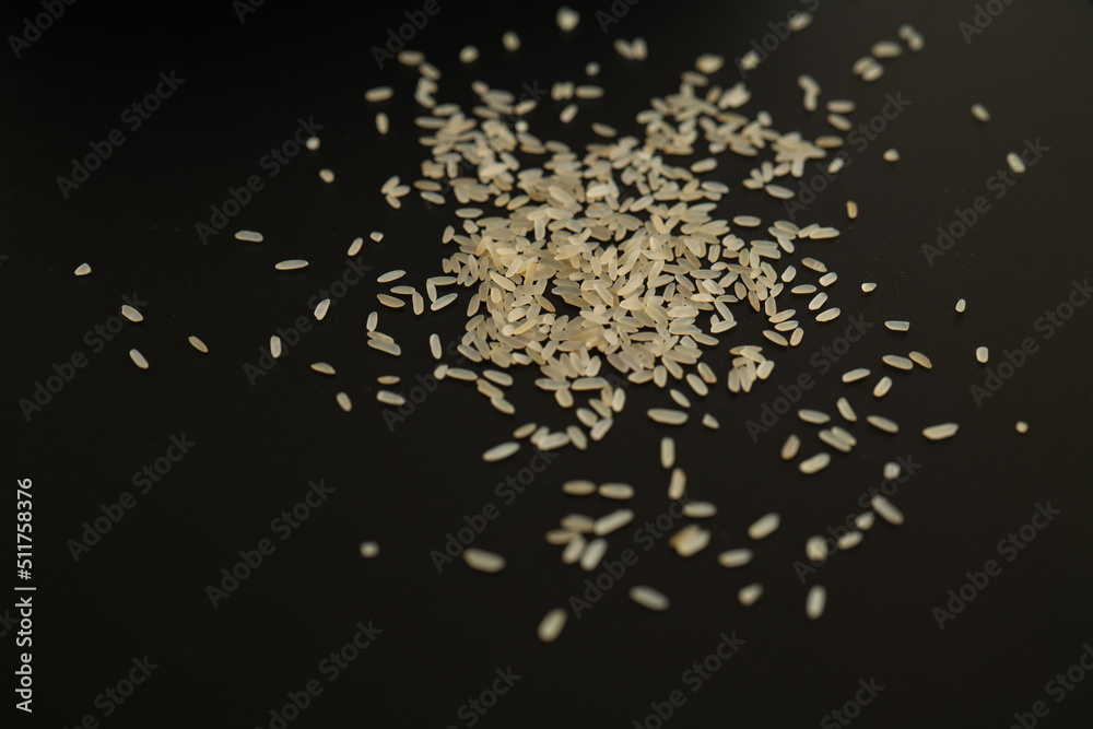 parboiled long-grain rice on a black background. organic coarse rice