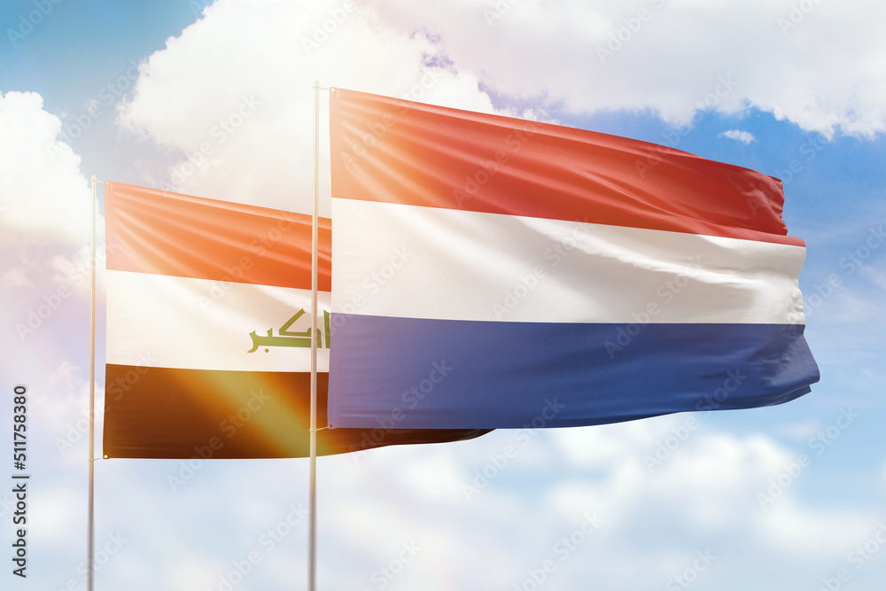 Sunny blue sky and flags of netherlands and iraq Sunny blue sky and flags of netherlands and iraq