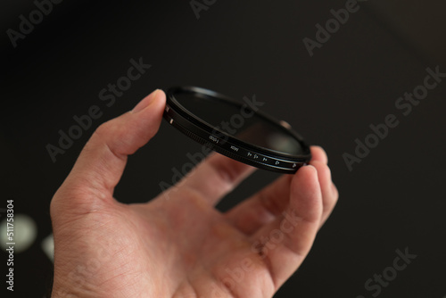 Billede på lærred mans hand holding filter neutral density on a black background
