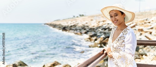 Photo Young hispanic woman smiling confident wearing summer hat at seaside