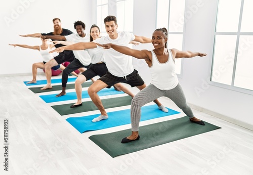 Group of young people smiling happy training yoga at sport center.