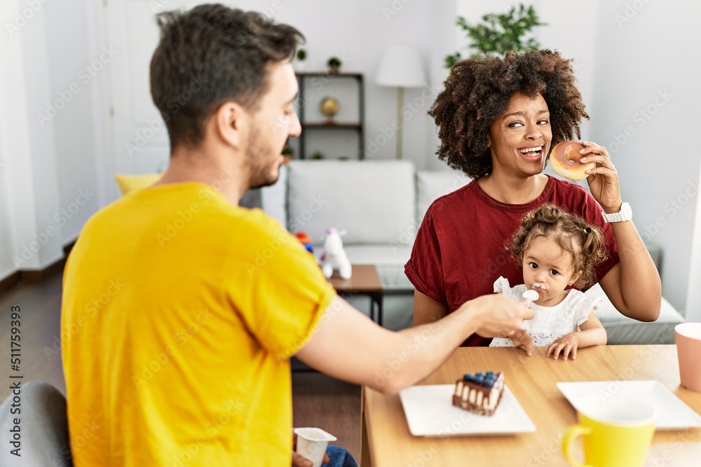 Couple and daughter having breakfast sitting on table at home Couple and daughter having breakfast sitting on table at home